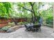 A relaxing outdoor patio with stone flooring, a dining table and beautiful trees and foliage at 3701 Eliot St, Denver, CO 80211