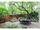 Inviting backyard patio with stone pavers, lush greenery, string lights and comfortable outdoor seating at 3701 Eliot St, Denver, CO 80211