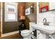 Charming powder room features a pedestal sink, dark paint, and eye-catching decorations at 3701 Eliot St, Denver, CO 80211