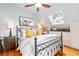 Cozy bedroom with a black metal bed frame, yellow pillows, a skylight, and light blue walls at 3701 Eliot St, Denver, CO 80211