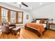 Inviting bedroom with hardwood floors, bay window, and reading chair at 3701 Eliot St, Denver, CO 80211