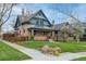 Charming brick two-story home with manicured lawn, mature trees, and inviting front porch at 3701 Eliot St, Denver, CO 80211