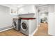 Well-equipped laundry room with a side-by-side washer and dryer and wood look floors at 3701 Eliot St, Denver, CO 80211