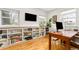 Bright home office featuring built-in shelves, a large window, and wood floors at 3701 Eliot St, Denver, CO 80211