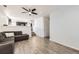 Open living room with L-shaped sofa, kitchen view, and wood-look floors at 5126 Elkhart St, Denver, CO 80239