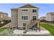 Back exterior of a two-story house with a patio, deck, and well-maintained lawn at 3620 Sandoval St, Brighton, CO 80601