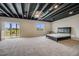 Finished basement area with exposed ceiling, plush carpet, and large windows at 3620 Sandoval St, Brighton, CO 80601