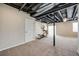 Finished basement area with exposed ceiling, plush carpet, and an elliptical machine at 3620 Sandoval St, Brighton, CO 80601