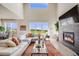 Bright living room with fireplace and large windows showcasing the scenic view at 3620 Sandoval St, Brighton, CO 80601