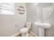 Modern powder room with a pedestal sink, round mirror, and geometric wall decor at 3620 Sandoval St, Brighton, CO 80601