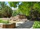 Backyard landscaping featuring a rock feature, mature trees, and flower beds at 517 Rider Ridge Dr, Longmont, CO 80504
