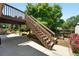 Stairs from the deck leading to a concrete patio and landscaped backyard with flower beds at 517 Rider Ridge Dr, Longmont, CO 80504