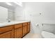 Bathroom featuring wood cabinets, large mirror, and tub with shower at 517 Rider Ridge Dr, Longmont, CO 80504