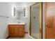 Bright bathroom featuring a wood vanity, and a glass-enclosed shower with gold trim at 517 Rider Ridge Dr, Longmont, CO 80504