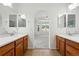 Open bathroom with double vanity and sinks, and an arched entry into a bedroom at 517 Rider Ridge Dr, Longmont, CO 80504