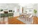 Open-concept dining room adjacent to the living room features a wooden table and a striped rug at 517 Rider Ridge Dr, Longmont, CO 80504