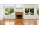Close up on the fireplace with hardwood floors and windows looking out on the greenery at 517 Rider Ridge Dr, Longmont, CO 80504