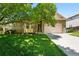 Charming stone-accented home with a well-manicured lawn and mature shade tree at 517 Rider Ridge Dr, Longmont, CO 80504