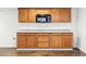 Basement kitchenette featuring wood cabinetry, granite counters, and a built in microwave at 517 Rider Ridge Dr, Longmont, CO 80504