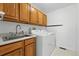 Functional laundry room featuring a utility sink, wood cabinets, and a washer and dryer at 517 Rider Ridge Dr, Longmont, CO 80504