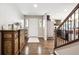 Welcoming entryway with hardwood floors, decorative console, and staircase at 22391 E Plymouth Cir, Aurora, CO 80016