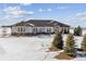 White modern ranch home with dark accents, snowy landscape, and mountain views at 7799 Two Rivers Cir, Parker, CO 80138