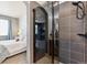 Sleek bathroom with glass-enclosed shower, stylish tile work, and view into bedroom at 16031 W 63Rd Ln # D, Arvada, CO 80403