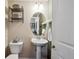 Charming half bathroom with pedestal sink, decorative mirror, and neutral color scheme at 16031 W 63Rd Ln # D, Arvada, CO 80403