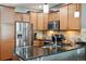 Updated kitchen featuring stainless steel appliances, granite countertops, and a stylish backsplash at 16031 W 63Rd Ln # D, Arvada, CO 80403