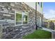 View of the side yard featuring stone and siding exterior and artificial grass at 4737 E Iliff Ave, Denver, CO 80222