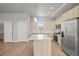 Modern kitchen with stainless steel appliances, light wood cabinets, and large island at 4737 E Iliff Ave, Denver, CO 80222
