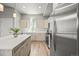 Modern kitchen boasts an island, sleek countertops, stainless steel appliances, and light wood cabinets at 4737 E Iliff Ave, Denver, CO 80222