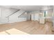 Expansive living area with open floor plan, hardwood floors, staircase, and a modern kitchen at 4737 E Iliff Ave, Denver, CO 80222