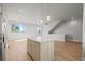 Bright, open-concept living space with kitchen island and hardwood floors at 4737 E Iliff Ave, Denver, CO 80222