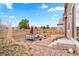 Outdoor patio seating area with gravel, greenery, and a view of the mountains beyond the fence at 8552 W San Juan Ave, Littleton, CO 80128