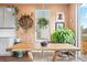 Dining area with natural wood table, plants, and bright natural lighting from windows and sliding glass door at 8552 W San Juan Ave, Littleton, CO 80128