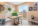 Bright dining area features a wooden table, bar stools, large windows, and ample natural light at 8552 W San Juan Ave, Littleton, CO 80128
