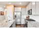 Modern kitchen featuring stainless steel appliances, granite countertops, and white cabinets at 8552 W San Juan Ave, Littleton, CO 80128