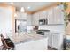 Modern kitchen featuring stainless steel appliances, granite countertops, and stylish pendant lighting at 8552 W San Juan Ave, Littleton, CO 80128