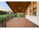 Expansive covered deck with ceiling fan overlooks serene yard at 6491 Crestbrook Dr, Morrison, CO 80465
