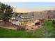 Expansive home featuring walls of windows, a deck, mature trees and a well-maintained lawn at 6491 Crestbrook Dr, Morrison, CO 80465