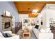 Open concept living area with wood floors, a fireplace and unique wood panel ceiling with skylights at 6491 Crestbrook Dr, Morrison, CO 80465
