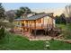 Rear exterior with wooden deck, landscaped yard, and walkout basement at 6491 Crestbrook Dr, Morrison, CO 80465
