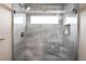Modern shower features sleek gray tile work, clear glass, and a bright transom window at 6491 Crestbrook Dr, Morrison, CO 80465