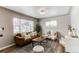 Inviting living room featuring a stylish brown leather sofa, neutral decor, and an abundance of natural light at 808 Hanover St, Aurora, CO 80010