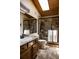 Bathroom showcases tiled floor, wood ceiling, granite counter, and tiled shower enclosure at 29101 Drexel Spur, Evergreen, CO 80439