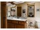 Bathroom featuring wood cabinets, granite counters, and a large mirror for a spacious look at 29101 Drexel Spur, Evergreen, CO 80439