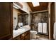 Elegant bathroom featuring granite counters, wood cabinets, and tiled shower enclosure for a luxurious feel at 29101 Drexel Spur, Evergreen, CO 80439