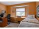 Cozy bedroom featuring an orange accent wall, built in window seat, and a sunny window at 29101 Drexel Spur, Evergreen, CO 80439
