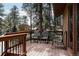 Exterior deck furnished with chairs, offering a serene outdoor space surrounded by tall trees and natural beauty at 29101 Drexel Spur, Evergreen, CO 80439